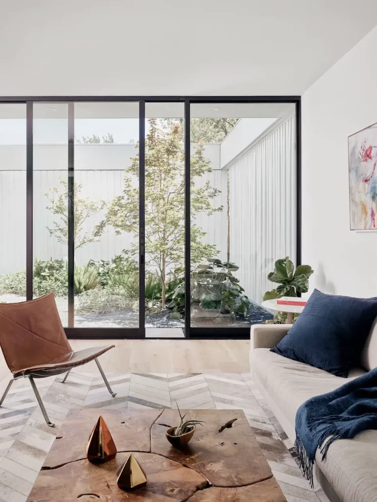 A living room with large windows and a coffee table is available to be found by an Austin Realtor through our real estate chat.