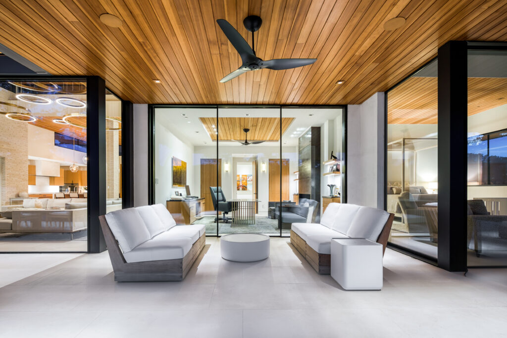 Looking for your dream home in Austin? Check out this modern living room with wooden ceilings and glass doors. Contact a local Realtor to start your home buying journey today!