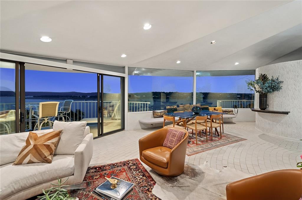 A living room with a balcony offering ocean views, perfect for home buying or real estate investment.