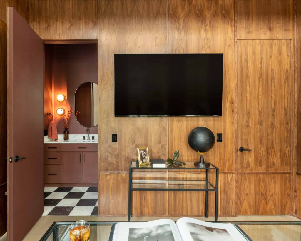 A bedroom with wood paneling and a TV is available for purchase in Austin. Would you like to chat about real estate opportunities with an expert Austin Realtor?