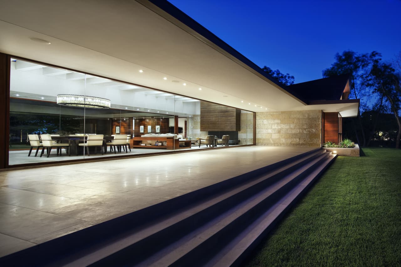 A modern house at night with a large glass door for sale in the real estate market.